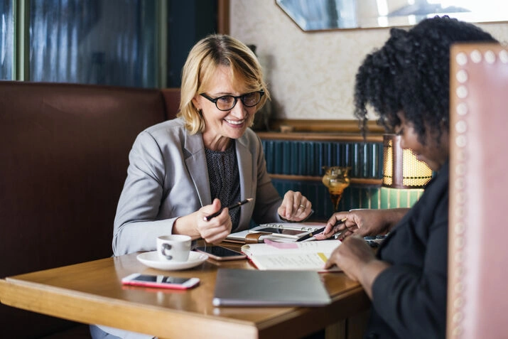 Two people reviewing documents together